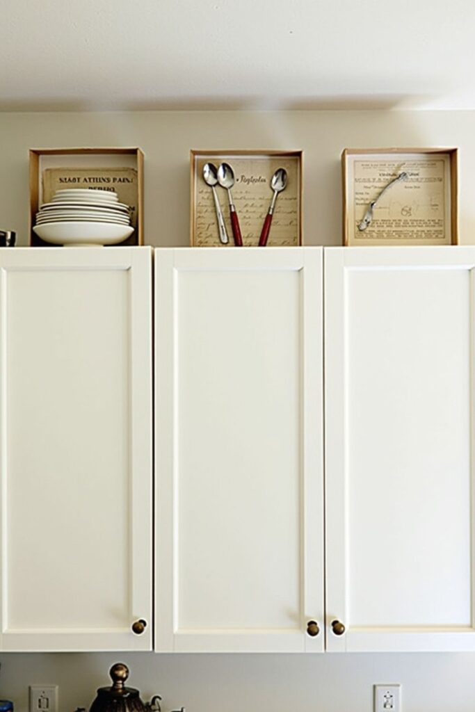 decor items displayed in enclosed boxes above kitchen cabinets to reduce dust and grease buildup